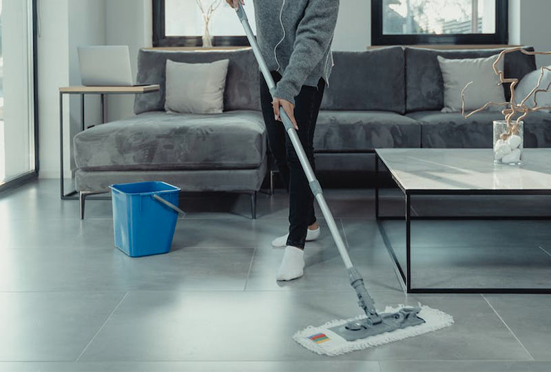 Woman cleaning a set of stone-effect porcelain floor tiles